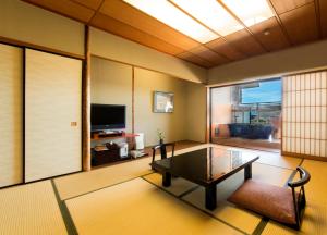 a living room with a coffee table and a television at Juhachiro in Gifu