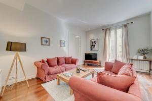 a living room with two pink couches and a table at BCN Apartments 41 in Barcelona