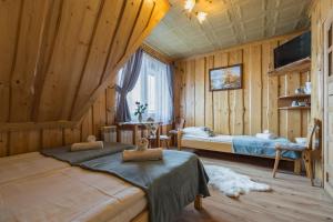 een slaapkamer met 2 bedden in een kamer met houten wanden bij Agrotatry U Stachy in Bukowina Tatrzańska