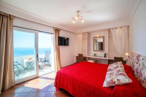 1 dormitorio con cama roja y ventana grande en Villa Anfitrite en Positano