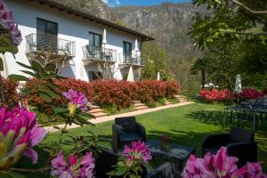 une maison avec un jardin et des fleurs devant elle dans l'établissement Hotel Al Fiume, à Tegna