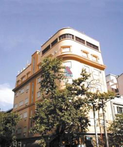 ein hohes Gebäude mit Bäumen davor in der Unterkunft Alcor Hotel in Mendoza