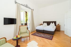 a living room with a bed and a chair at Seehaus Familie Leifer in St. Wolfgang