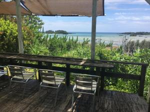 a table and chairs with a view of the ocean at Minami Onna Tropical in Onna