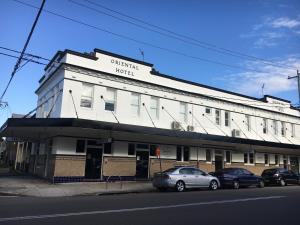 紐卡索的住宿－東方大酒店，一座白色的建筑,前面有汽车停放