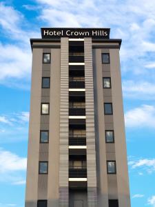 un edificio con un cartello sopra di Hotel Crown Hills Iwaki a Iwaki