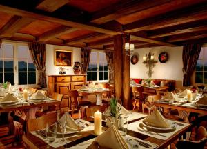 a dining room with tables and chairs and windows at Bürgenstock Hotels & Resort - Taverne 1879 in Bürgenstock