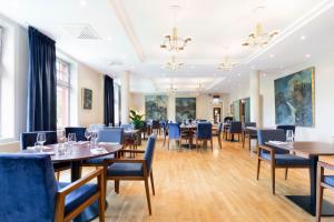 een eetkamer met tafels en blauwe stoelen bij Tyssedal Hotel in Tyssedal