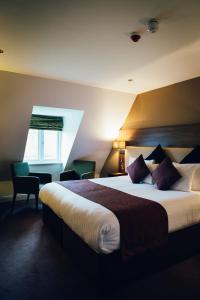 a hotel room with a large bed and a window at Letchworth Hall in Letchworth