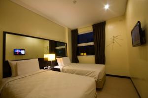 سرير أو أسرّة في غرفة في Go Hotels Dumaguete