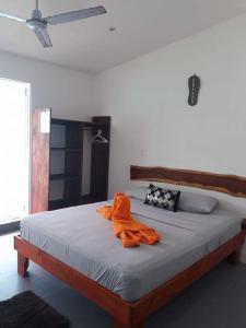 een slaapkamer met een bed met een oranje badjas erop bij Oasis in Sámara