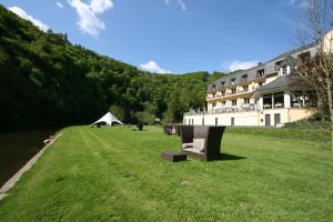 um grande campo relvado ao lado de um grande edifício em Cocoon Hotel Belair em Bourscheid