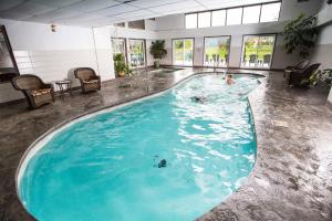 a large swimming pool with two people swimming in it at Hotel Bromont in Bromont