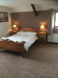 una camera con letto in legno e 2 comodini di Stone Cottage a Ponteland