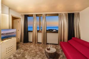 ein Wohnzimmer mit einem roten Sofa und einem großen Fenster in der Unterkunft The View Luxury Rooms in Split