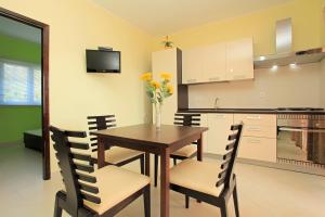 cocina y comedor con mesa de madera y sillas en D&A Apartments, en Vela Luka