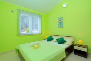 Dormitorio verde con 2 camas y ventana en D&A Apartments, en Vela Luka