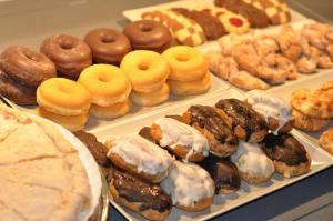 une exposition de différents types de beignets et de pâtisseries dans l'établissement Hotel Selu, à Cordoue