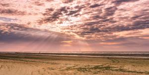 - une plage avec un ciel nuageux et l'océan dans l'établissement Hotel Prado, à Ostende