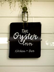 een bord dat de eigen keukenbar aan een deur leest bij The Oyster Inn in Oneroa