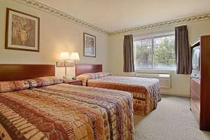 a hotel room with two beds and a window at Days Inn by Wyndham Cleveland Lakewood in Lakewood