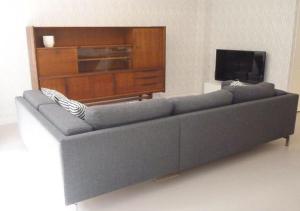 a blue couch in a living room with a tv at Retro farmhouse Cadzand, Koolse Hoeve 1H in Cadzand