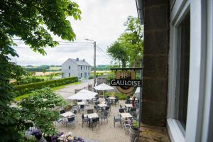 un groupe de tables et de chaises à l'extérieur d'un bâtiment dans l'établissement B&B Le Vieux Marronnier, à Foy-Notre-Dame