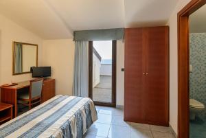 um quarto de hotel com uma cama, uma secretária e uma casa de banho em Hotel Serenella em Agropoli