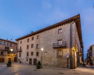 um grande edifício de tijolos com uma varanda numa rua em Palacio de Pujadas by MIJ em Viana