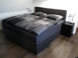 een groot bed met een zwart bedframe in een slaapkamer bij Ferienwohnung Berger Bocholt in Bocholt