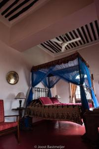 um quarto com uma cama de dossel azul em Zanzibar Palace Hotel em Zanzibar City