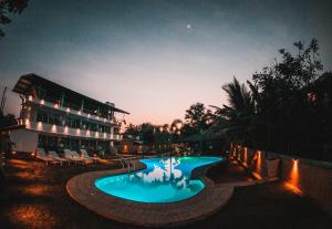 una piscina frente a un edificio por la noche en Royal Rock Sigiriya, en Sigiriya