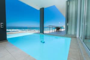 a swimming pool in a building with a view of the ocean at MGM Wilderness in Wilderness