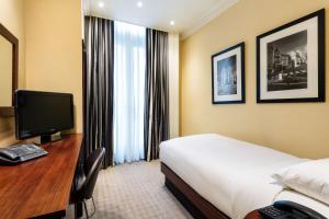 a hotel room with a bed and a desk with a computer at Radisson Blu Hotel, London South Kensington - formerly Vanderbilt in London