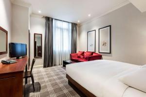 a hotel room with a bed and a desk and a chair at Radisson Blu Hotel, London South Kensington - formerly Vanderbilt in London