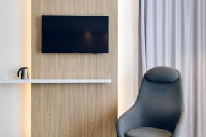 Pokój z krzesłem i telewizorem na ścianie w obiekcie Holiday Inn Express - Rzeszow Airport, an IHG Hotel w mieście Rzeszów