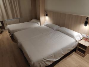 バルセロナにあるHostal BESTPRICE Barcelona Stadiumのホテルルーム ベッド2台 白いシーツ付