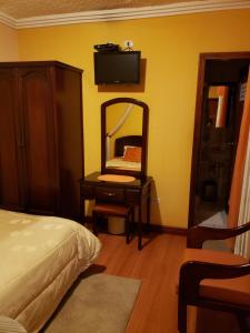 een slaapkamer met een bed, een spiegel en een dressoir bij Lloresa in Cuenca