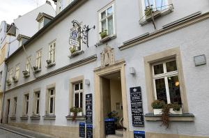 un bâtiment blanc avec un panneau devant lui dans l'établissement Münchner Hofbräu Coburg, à Cobourg