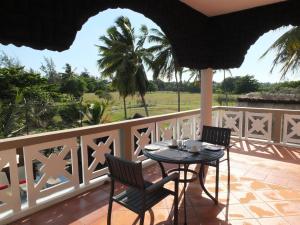 patio con mesa y sillas en el balcón en Eden Villa en Belle Mare