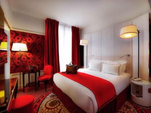 una camera d'albergo con un grande letto e tende rosse di Hotel Carlton Lyon - MGallery Hotel Collection a Lione