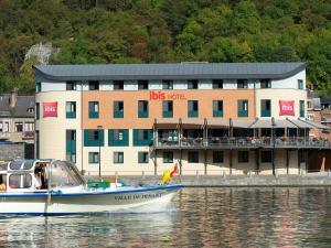 um barco na água em frente a um edifício em ibis Dinant Centre em Dinant