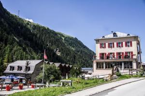 um edifício ao lado de uma estrada ao lado de uma montanha em Hôtel Le Besso - Swiss Romantic Lodge Zinal em Zinal