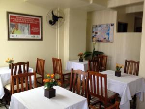 un comedor con mesas y sillas con flores. en Hotel Linhares, en Itajaí