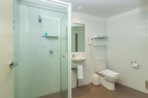 a bathroom with a shower and a toilet and a sink at The Dorsal Boutique Hotel in Forster