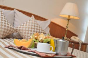 een dienblad met een bord eten op een bed bij Hotel Los Cedros in Salto