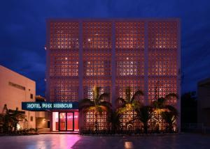 Un grand bâtiment avec des lumières allumées la nuit dans l'établissement HOTEL PINK HIBISCUS, à Île Miyako