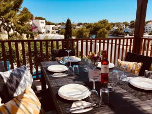 uma mesa com pratos e copos de vinho numa varanda em Villa Imperial em Cala d´Or