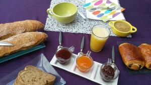 un tavolo viola con pane, pane tostato e bevande di Les Jardins du Golf a Metz