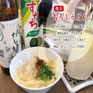 un tazón de fideos con una botella de vino en Super Hotel Marugame Ekimae en Marugame